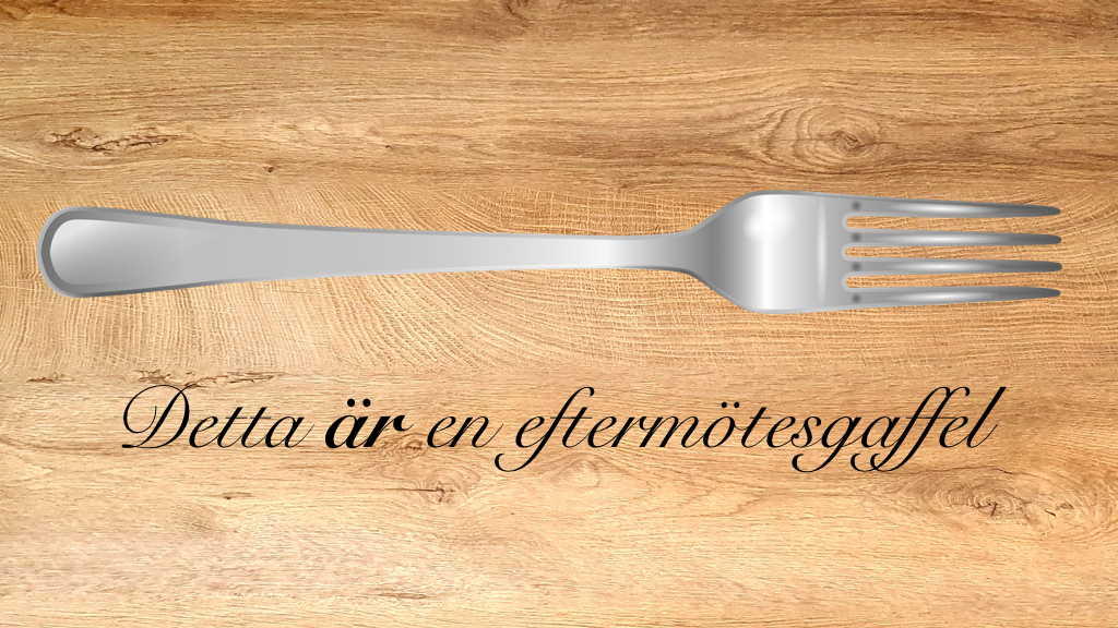 En gaffel på en träbordsskiva. Under gaffeln står texten "Detta är en eftermötesgaffel".