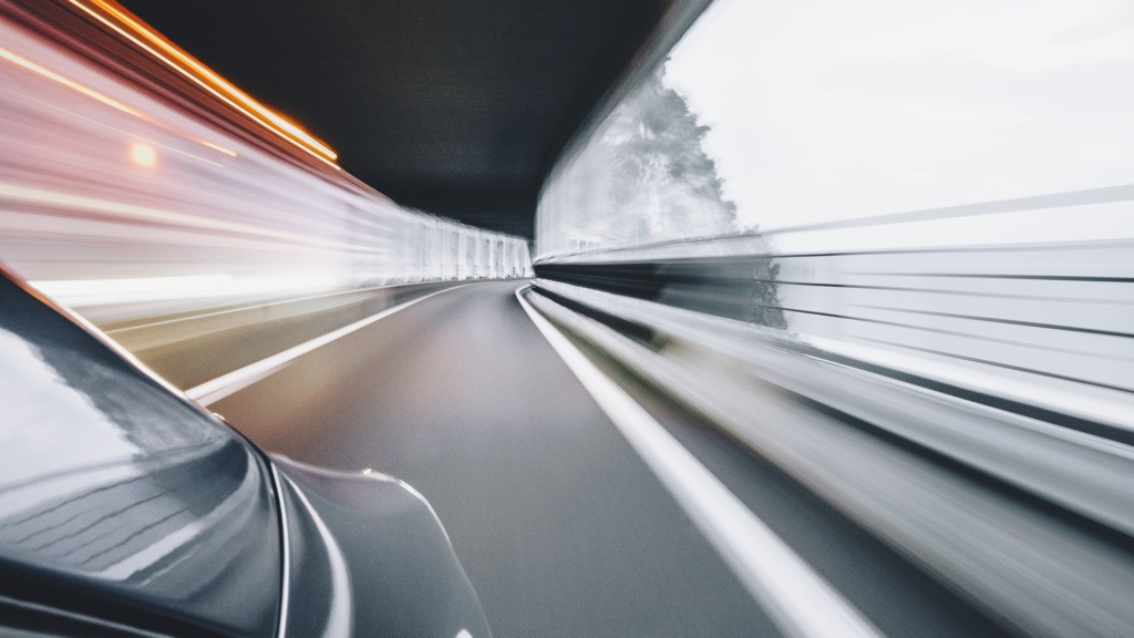 A rear facing view from a car speeding on a mountain road.