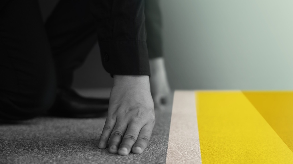 A person dressed in business attire is in a starting position at a yellow starting line, ready to take off.