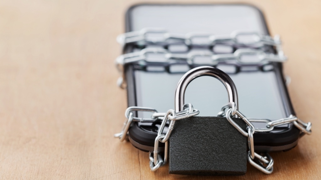A smartphone is secured with a chain and padlock.