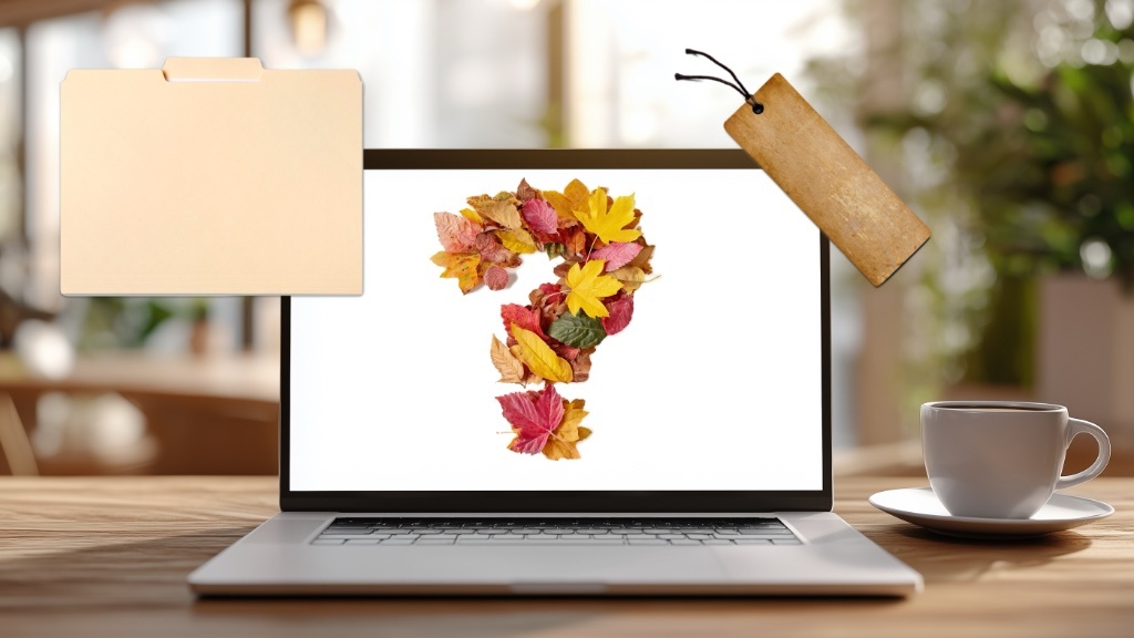 En laptop som visar ett frågetecken gjort av färgglada höstlöv står på ett träbord bredvid en kaffekopp, med en mappikon och en etikett svävande ovanför.