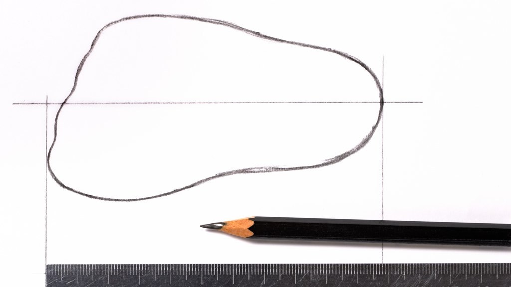 Fri cirkulär form ritad med blyertspenna på vitt blad. Under formen ligger en blyertspenna och en linjal.
