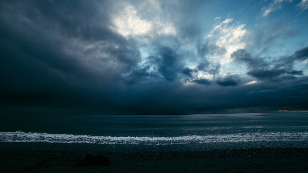 A dark sky over a calm beach.