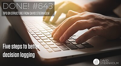 Hands are typing on a laptop keyboard, illuminated by warm sunlight coming from the side.
