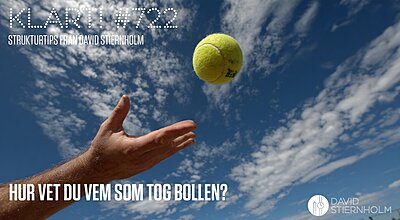 En hand sträcks upp för att fånga en tennisboll mot en klarblå himmel med spridda moln.