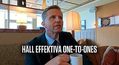 En man i kostym sitter på ett café och håller i en kaffemugg, med den svenska texten "HÅLL EFFEKTIVA ONE-TO-ONES" synlig över bilden.