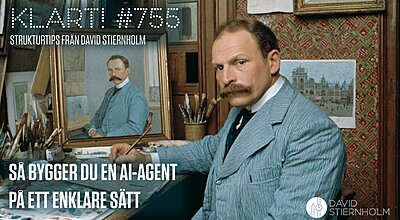 En mustaschprydd man i randig kostym sitter vid ett målarbord och håller en pensel, med ett porträttmåleri av honom själv synligt i bakgrunden.