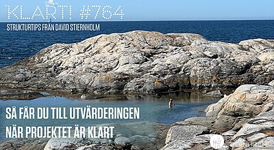 En person simmar i en naturlig klipppool längs ett kargt kustlandskap med det öppna havet och en klar blå himmel i bakgrunden.