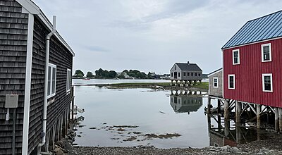 Havsvy med tre hus på styltor i Cape Porpoise, Maine