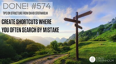 A wooden signpost by a foot path through a beautiful, green, mountaineous pastoral landscape.