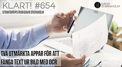 En person scannar ett dokument med sin telefon bredvid en bärbar dator och glasögon på ett skrivbord.